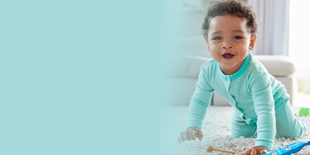 Smiling baby crawling on a rug