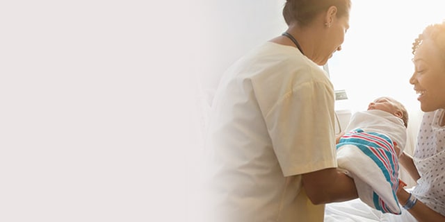Nurse handing a woman her newborn baby
