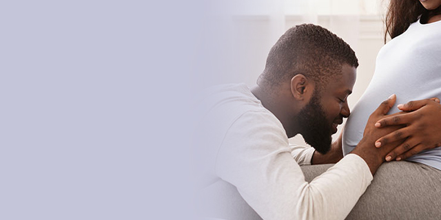 Man kissing his partner's pregnant belly