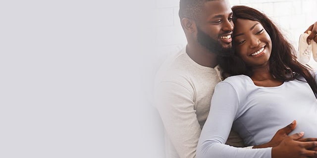 Smiling man and woman looking at baby shoes