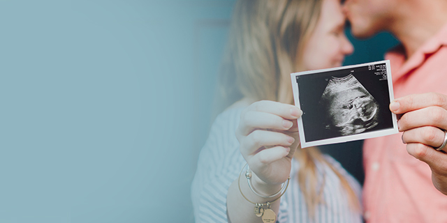 Happy pregnant couple showing an ultrasound picture